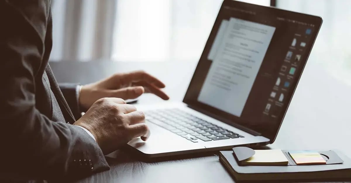 2 hands typing and scrolling in a laptop