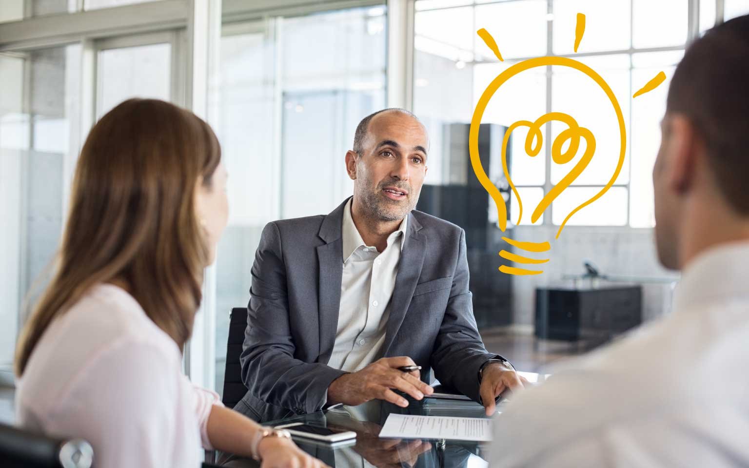 An advisor explains a new idea to two people in a meeting.